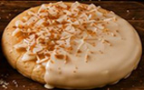 Sugar cookie dipped in Coquito glaze topped with toasted coconut and cinnamon